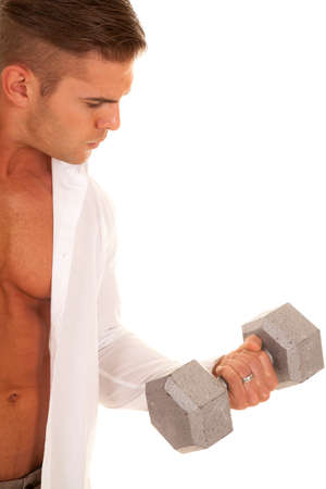 A man with his shirt unbuttoned lifting his weights.の写真素材