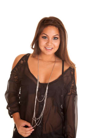A woman in her sheer top playing with a necklace around her neck.の写真素材