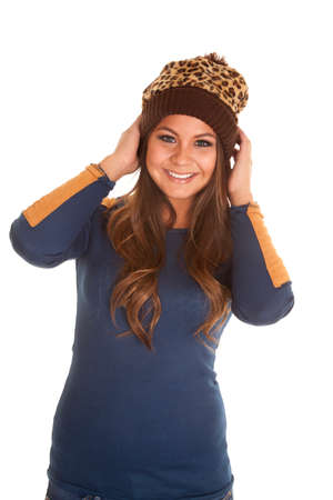 A woman with a smile holding on to her beanie.の写真素材