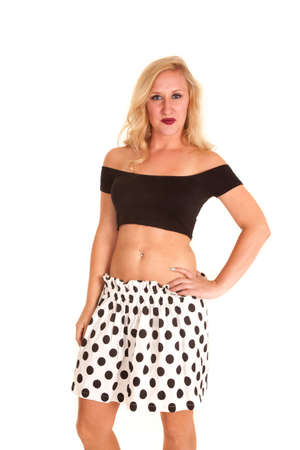 a woman in a polka dot skirt and a black top showing off her stomach.の写真素材