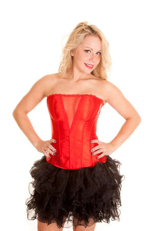 A woman wearing a red corset with her black tutu.  She has a smile on her face and her hands on her hips.の写真素材