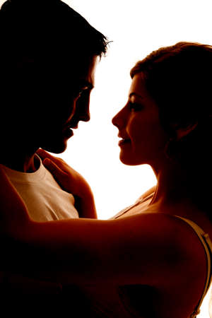 a silhouette of a man and woman with their arms around each other.の写真素材