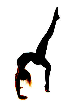 A silhouette of a woman doing a back bend with her legs split.の写真素材