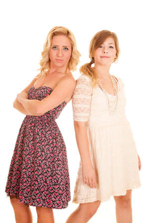 two women standing back to back in their dresses.の写真素材
