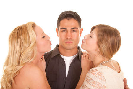 A man with a serious expression getting ready for two women kissing him.の写真素材