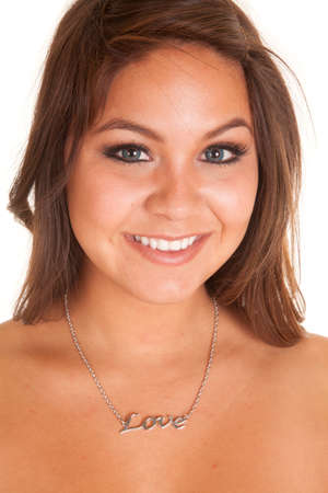 A woman with a smile on her face, wearing a love necklace.の写真素材