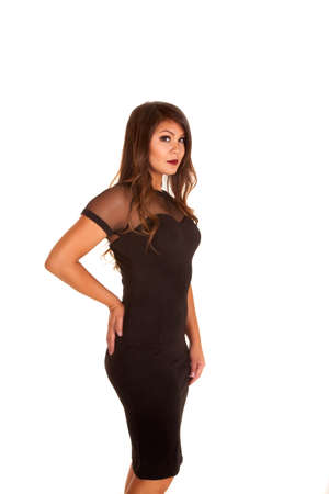 a woman in her black fitted dress with her hand on her hip.の写真素材