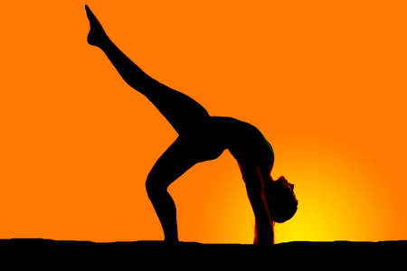 a woman doing a back bend in the outdoors.