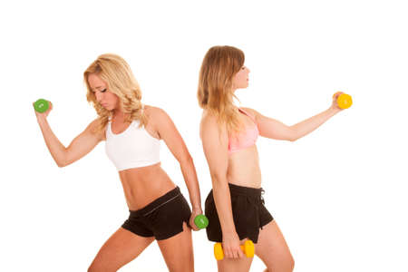 Two women working out with weights in their sports bras.の写真素材
