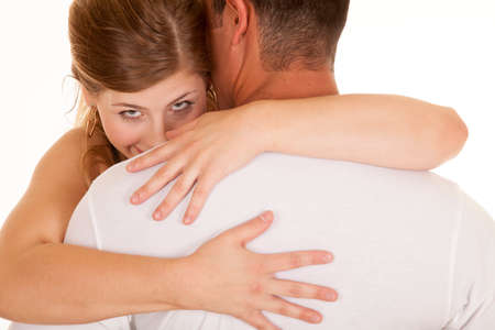 a woman with her arms wrapped around her man looking.の写真素材