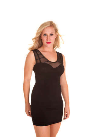 A woman in a short black fitted dress with a serious expression.の写真素材