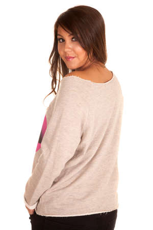 A woman in her warm bulky sweater looking over her shoulder.の写真素材