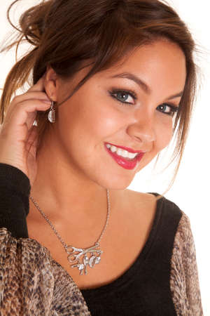 A woman with a smile, showing off her earring and necklace.の写真素材