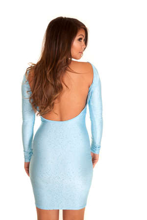 A woman showing the back of her blue dress, looking over her shoulder.の写真素材