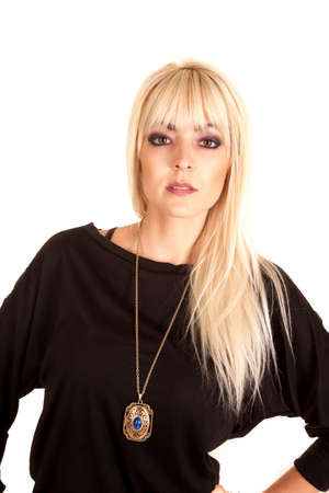A woman with a serious expression wearing a black shirt and a necklace with a blue rhinestone.の写真素材