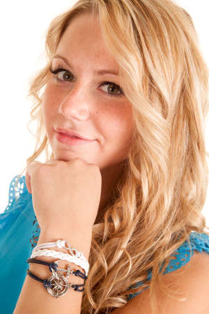 a woman in a blue top with her hand on her chin, wearing bracelets.の写真素材