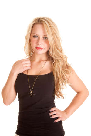 A woman with her hand on her shoulder looking, wearing a black tank and a necklace.の写真素材