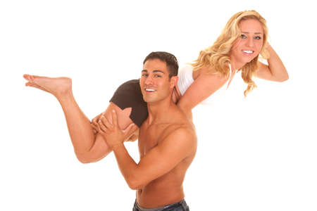 A man lifting up his woman over his shoulder.  They are smiling.の写真素材