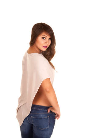 a woman with her hand on her hip jeans skin showing.の写真素材