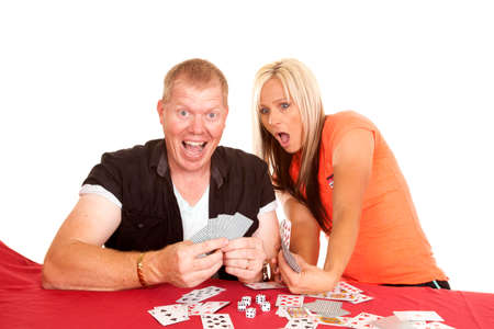 A man is happy about his good hand, the woman is shocked at his cards.の写真素材