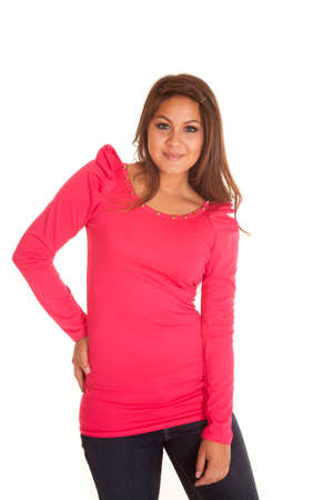 A woman in her pink top with her hand on her hip smile.の写真素材