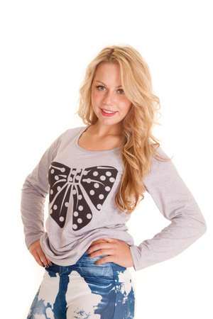 A woman in her polka dot sweater, with her hands on her hips with a smileの写真素材