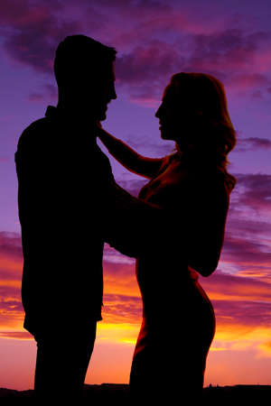 a silhouette of a man and woman getting close to each other,の写真素材