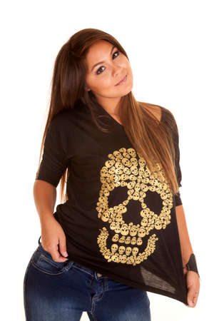 a woman playing with her skull shirt with a small smile.の写真素材