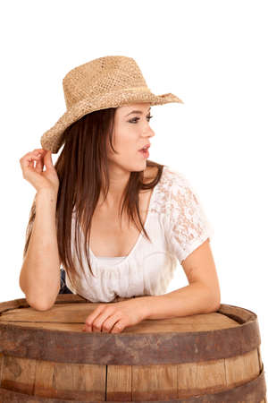 A cowgirl looking to the side, leaning on a barrel.の写真素材