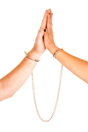 A man and woman with their hands touching with handcuffs on their wrists.の写真素材