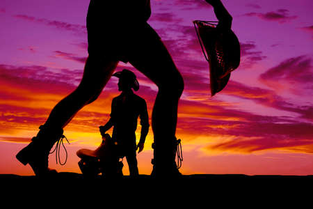 A silhouette of a woman's legs with a cowboy silhouette in the middle of them.の写真素材
