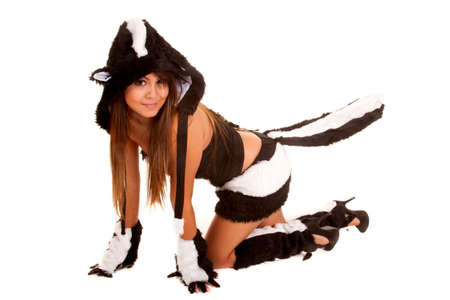 A woman in her skunk costume crawling on the ground with her tail in the air.の写真素材