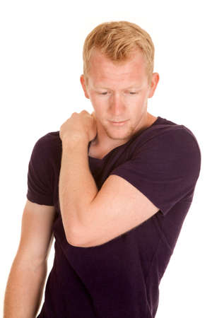 a man in a purple shirt with his hand on his shoulder looking down.の写真素材