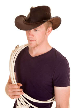 A man in his purple shirt with a rope on his houlder wearing a cowboy hat.の写真素材