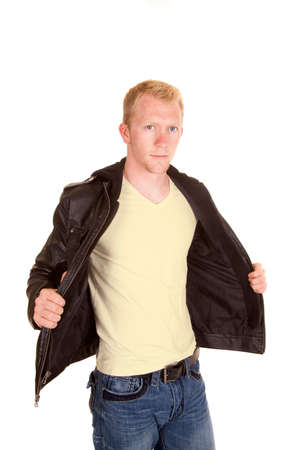 A man in his black leather jacket holding it open with a serious expression on his faceの写真素材