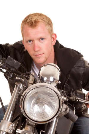 A man leaning forward over the handle bars on his motorcycle.の写真素材