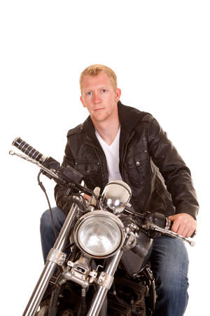 A man sitting on his motorcycle with a serious expression on his face.の写真素材