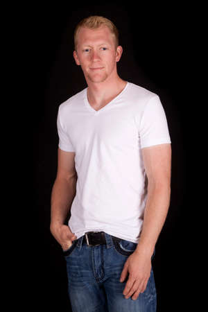 A man standing on a black background with his hand in his pocket.の写真素材