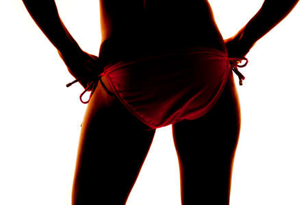 A silhouette of a woman from the back in her bikini bottom.の写真素材