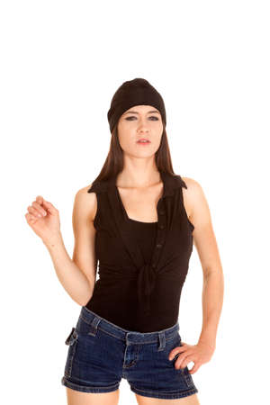 a woman with a serious expression on her face with her black bandana and short jean shorts.の写真素材