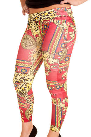 A woman in her red and gold leggings with her hands on her hips.の写真素材
