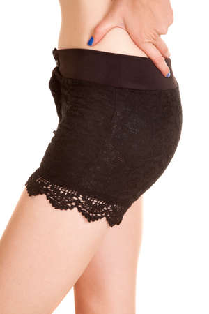 A side view of a woman in her lace shorts with her hands on her hip.の写真素材