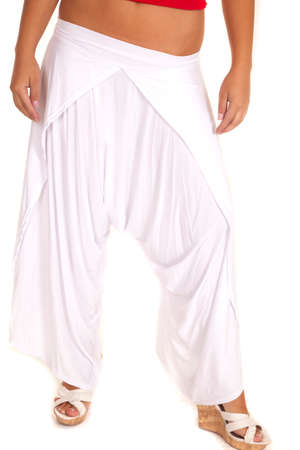 A woman in her white genie pants posing.の写真素材