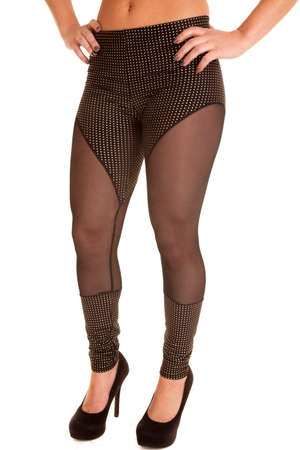 A woman with her hands on her hips in her leggings with sheer material.の写真素材