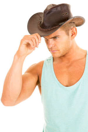a cowboy touching the brim of his at looking down.の写真素材