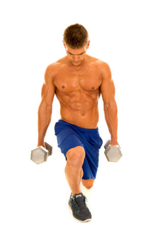 A man doing a lunge holding on to weights looking up with a smile.の写真素材