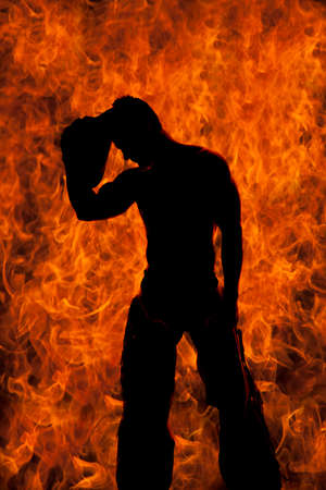 A silhouette of a cowboy with fire behind him, putting his hat on his head.