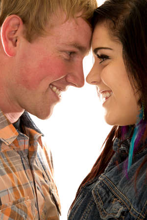 A couple looking into each other's eyes with big smiles on their faces.の写真素材