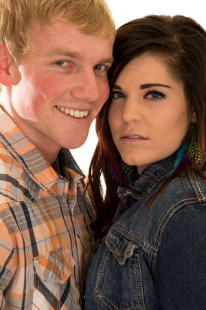 a woman and man with their faces together, he has a smile and she is serious.の写真素材