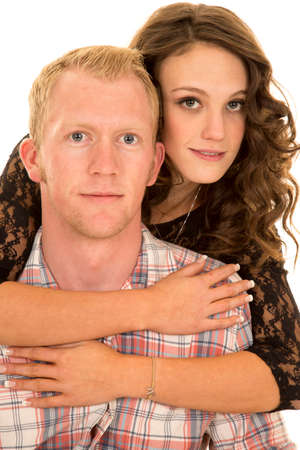 A woman holding on to her man around his shoulders.の写真素材